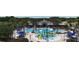 A beautiful community pool and splash pad with lounge chairs and palm trees for relaxing at 8922 Little Bluestem Dr, Land O Lakes, FL 34637