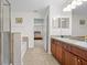 This bathroom offers a tub, tiled floors, and dual sinks with wood cabinetry at 9206 River Rock Ln, Riverview, FL 33578
