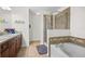 Bathroom features a soaking tub, glass-enclosed shower, and a double sink vanity at 9206 River Rock Ln, Riverview, FL 33578