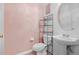 Bathroom features a pedestal sink, toilet, tile floors, and shelving unit at 9206 River Rock Ln, Riverview, FL 33578