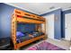 Bedroom featuring a bunk bed, closet, blue walls, and a colorful rug at 9206 River Rock Ln, Riverview, FL 33578
