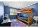 Bedroom with a bunk bed, blue walls, ceiling fan, and a colorful rug at 9206 River Rock Ln, Riverview, FL 33578