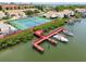 Aerial view showcases private boat dock, tennis court, and waterfront condos in a beautiful coastal community at 4304 Harbor House Dr, Tampa, FL 33615