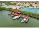 Aerial view of waterfront community with private docks, boats, tennis courts, and lush tropical surroundings at 4304 Harbor House Dr, Tampa, FL 33615