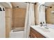 Bathroom featuring neutral-toned tile, tub-shower with white curtain, and vanity with framed mirror at 4304 Harbor House Dr, Tampa, FL 33615