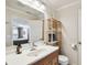 Bathroom with a wooden vanity, ample lighting, a framed mirror, and decorative shelving at 4304 Harbor House Dr, Tampa, FL 33615