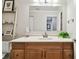This bathroom features a vanity with a wood cabinet, a white sink, and a large mirror at 4304 Harbor House Dr, Tampa, FL 33615