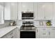 A stainless range and microwave accent this kitchen's white cabinets and quartz counters with a view of the community at 4304 Harbor House Dr, Tampa, FL 33615