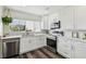 An updated kitchen features stainless appliances, white cabinets, quartz countertops, and a view of the marina at 4304 Harbor House Dr, Tampa, FL 33615