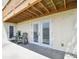 A cozy patio with outdoor seating under a wooden balcony, accessible through double glass doors at 4304 Harbor House Dr, Tampa, FL 33615