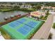 Aerial view of tennis courts in a waterfront community with clubhouse, boat docks, and lush landscaping at 4304 Harbor House Dr, Tampa, FL 33615