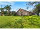 Spacious backyard features lush green grass, a screened-in pool, and mature trees, perfect for outdoor enjoyment at 10101 Paddock Oaks Dr, Riverview, FL 33569