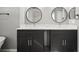 Stylish bathroom with double vanity, dark cabinetry, quartz countertop, and modern round mirrors at 10101 Paddock Oaks Dr, Riverview, FL 33569