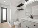 Bathroom featuring floating shelves, modern fixtures, and a tiled shower visible through glass door at 10101 Paddock Oaks Dr, Riverview, FL 33569