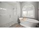 Modern bathroom featuring glass shower, standalone tub, and unique flooring accents this relaxing space at 10101 Paddock Oaks Dr, Riverview, FL 33569