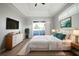 Bright bedroom features a tray ceiling, light gray walls, and sliding glass doors to the outdoor patio at 10101 Paddock Oaks Dr, Riverview, FL 33569