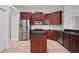 Kitchen showcases dark wood cabinets, stainless steel appliances, and a center island with a cooktop at 10101 Paddock Oaks Dr, Riverview, FL 33569