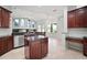 Kitchen with a dark wood island, countertops, stainless steel appliances, and scenic backyard views at 10101 Paddock Oaks Dr, Riverview, FL 33569