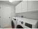 Bright laundry room with modern washer and dryer units and storage cabinets at 10101 Paddock Oaks Dr, Riverview, FL 33569