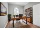 Functional home office featuring a large wooden desk, a bookshelf, and a comfortable chair for remote work at 10101 Paddock Oaks Dr, Riverview, FL 33569