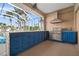 Outdoor kitchen featuring custom blue cabinets and stainless steel appliances overlooking the pool at 10101 Paddock Oaks Dr, Riverview, FL 33569