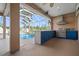 Covered outdoor kitchen boasts a built-in grill, blue cabinets, and ample countertop space near the pool at 10101 Paddock Oaks Dr, Riverview, FL 33569