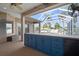 Covered outdoor kitchen featuring blue cabinets, stainless steel grill, and poolside view at 10101 Paddock Oaks Dr, Riverview, FL 33569