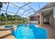 Sparkling pool and spa with screened enclosure and an outdoor kitchen area at 10101 Paddock Oaks Dr, Riverview, FL 33569