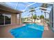 Inviting screened-in pool with clear blue water, tropical trees, and well maintained landscaping at 10101 Paddock Oaks Dr, Riverview, FL 33569