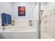 Bright bathroom featuring an oval tub, a glass-enclosed shower, and modern decor at 1031 Andrew Aviles Cir, Tampa, FL 33619