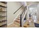 Modern staircase featuring wooden treads, white risers, and a sleek black handrail, plus open floorplan at 1031 Andrew Aviles Cir, Tampa, FL 33619