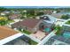Aerial view of a home with a screened-in pool, manicured lawn, and neighborhood view at 10327 Meadow Crossing Dr, Tampa, FL 33647