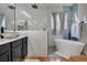 Serene bathroom with a modern freestanding tub, walk-in shower, and stylish vanity, creating a luxurious and relaxing atmosphere at 10327 Meadow Crossing Dr, Tampa, FL 33647