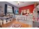 Bright bedroom with a red accent wall, cozy decor, and ample shelving for storage and display at 10327 Meadow Crossing Dr, Tampa, FL 33647