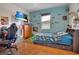 Fun bedroom with blue accent wall, a TV, dinosaur accents, and ample space, fostering a creative and playful environment at 10327 Meadow Crossing Dr, Tampa, FL 33647