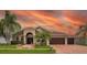 Charming single-Gathering home features a well-manicured lawn, mature palm trees, brick driveway, and a 3-car garage at 10327 Meadow Crossing Dr, Tampa, FL 33647