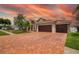 Exterior elevation features an oversized three car garage and brick paver driveway at 10327 Meadow Crossing Dr, Tampa, FL 33647