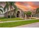 Charming one story home with an arched entryway, mature palm trees, and a well manicured lawn at 10327 Meadow Crossing Dr, Tampa, FL 33647