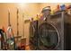 Functional laundry room featuring a modern washer and dryer with storage shelving and cleaning supplies at 10327 Meadow Crossing Dr, Tampa, FL 33647