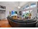 Open-concept living area with a large sectional, ceiling fan, and sliding glass doors to a screened-in patio, creating an indoor-outdoor flow at 10327 Meadow Crossing Dr, Tampa, FL 33647