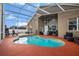 Private screened-in pool with lounge seating, a built-in barbecue area, and lush landscaping at 10327 Meadow Crossing Dr, Tampa, FL 33647