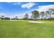Scenic golf course view with manicured greens, sand traps, and lush landscaping under a blue sky at 11220 Paradise Pointe Way, New Port Richey, FL 34654