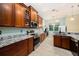 Well-lit kitchen with granite countertops, stainless appliances, and wood cabinetry at 11220 Paradise Pointe Way, New Port Richey, FL 34654