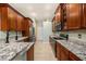 Well-lit kitchen with granite countertops, stainless appliances, and wood cabinetry at 11220 Paradise Pointe Way, New Port Richey, FL 34654
