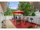 Outdoor patio with red pavers, sun umbrella, and wrought iron seating area at 12529 Knollbrook Ln, Hudson, FL 34669