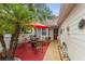 Cozy outdoor patio space with red brick pavers, sun umbrella, and outdoor furniture at 12529 Knollbrook Ln, Hudson, FL 34669