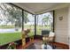 Inviting screened porch with comfortable seating and serene views of the pond at 12529 Knollbrook Ln, Hudson, FL 34669