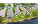 Aerial view of homes near a serene lake and lush greenery, with screened in pools at 12631 Chenwood Ave, Hudson, FL 34669
