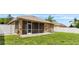 Exterior view of screened lanai and backyard, offering a private and peaceful outdoor setting at 12631 Chenwood Ave, Hudson, FL 34669