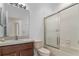 Bright bathroom featuring a vanity with sink and a bathtub with sliding glass doors at 12631 Chenwood Ave, Hudson, FL 34669